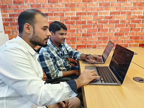 ImmensoTech developers reviewing software code together on laptops