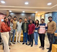 mmensoTech software development team standing together for a group photo in a modern office lounge